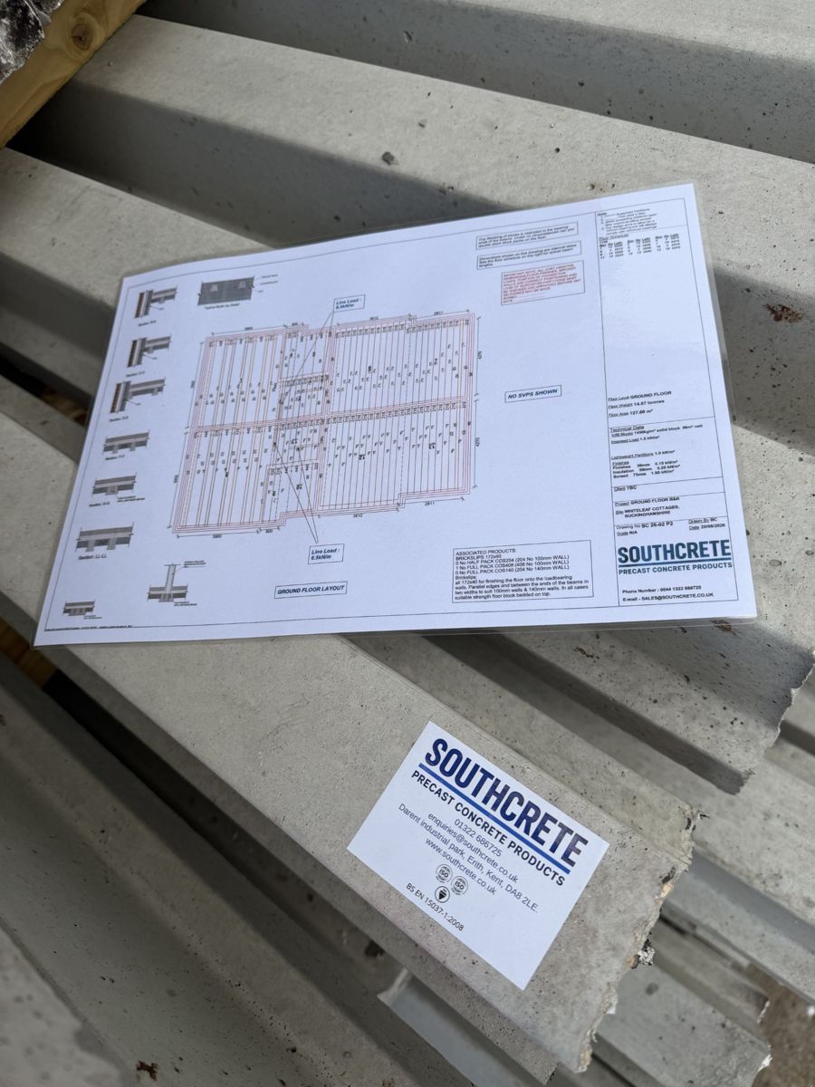 A Southcrete floor layout plan lying on stacked concrete beams